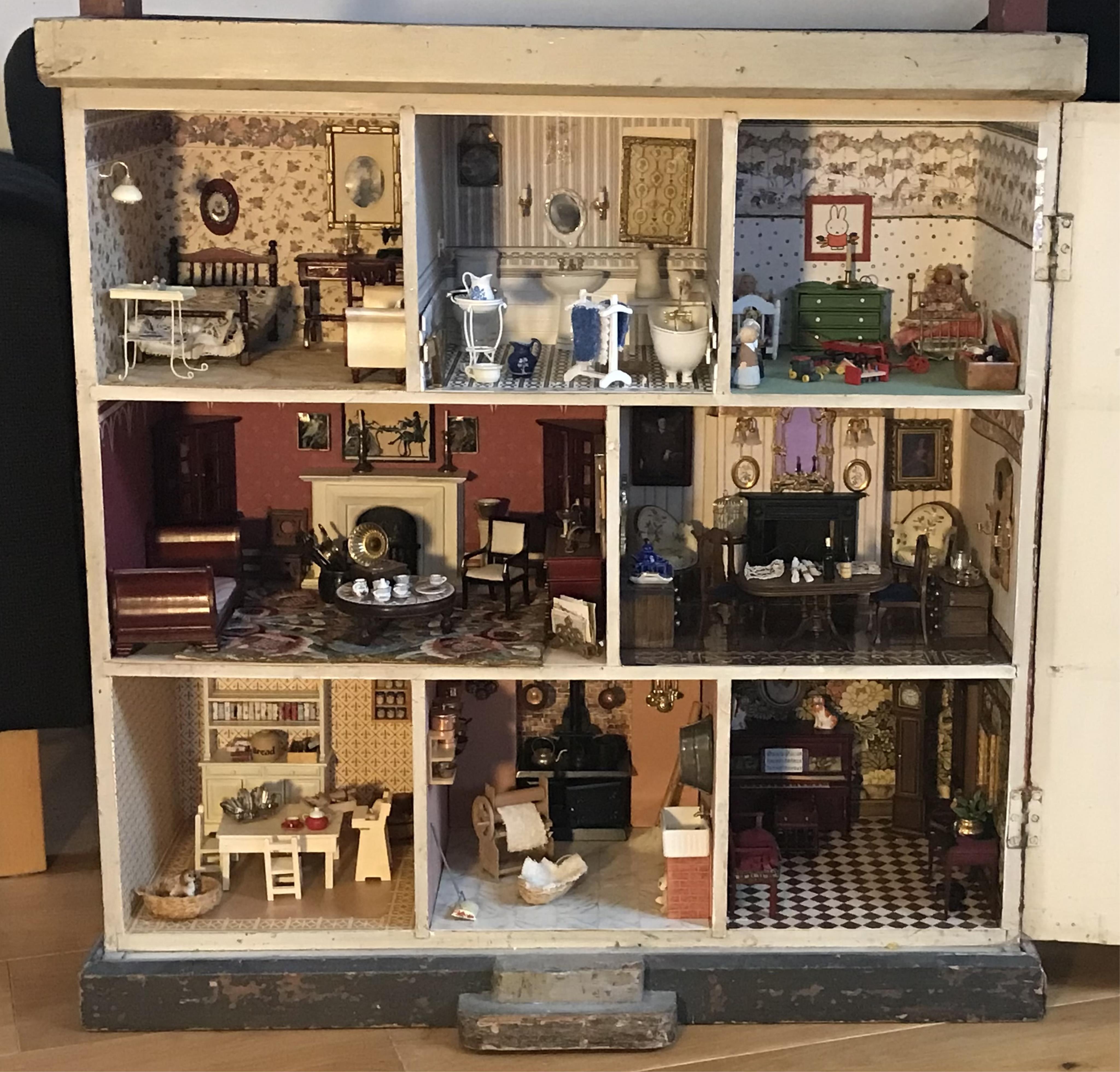 A late 19th century doll's house, with a single front opening panel, incorporating eight internal rooms, flat roof with parapet, dimensions 81.5cm high, 79cm wide, 30cm deep, together with modern manufactured furniture a